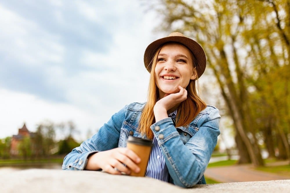 young lady have a cup of coffee outside